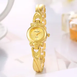 Vue détaillée d'une montre à quartz dorée pour femme avec bracelet à maillons croisés.