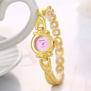 Vue détaillée d'une montre femme dorée élégante avec cadran rose et bracelet croisé