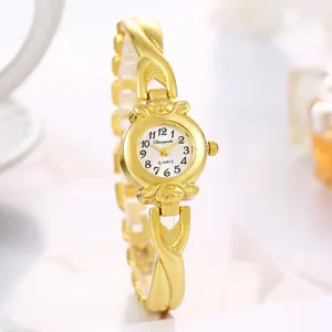 Détail exquis d'une montre à quartz pour femme avec bracelet doré croisé et cadran blanc
