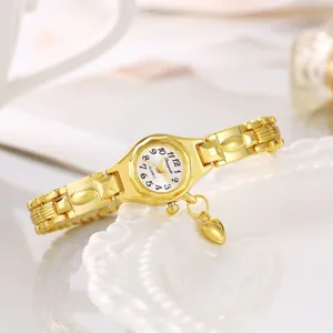 Primo piano dell'elegante orologio a bracciale dorato da donna con ciondolo a cuore