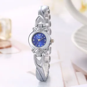 Gros plan d'une montre à quartz argentée pour femme avec cadran bleu et bracelet croisé