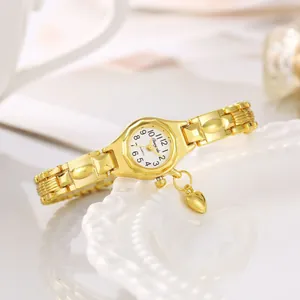 Vista dettagliata di un elegante orologio da polso dorato da donna con un piccolo cuore.