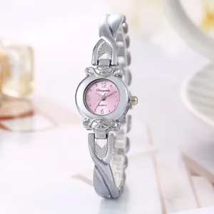 Gros plan d'une montre à quartz pour femme avec cadran rose et bracelet argenté croisé