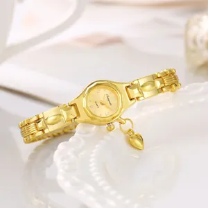 Dettaglio di un orologio bracciale da donna dorato con ciondolo a forma di cuore