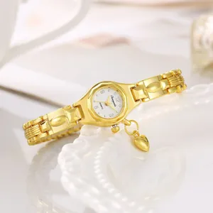Vista dettagliata di un elegante orologio da polso dorato da donna con ciondolo a cuore
