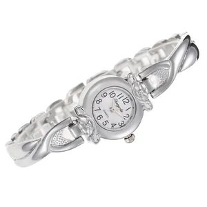 Gros plan d'une montre à quartz pour femme avec bracelet croisé argenté et détails de fleurs