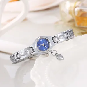 Primo piano di un orologio da polso argento da donna con ciondolo a cuore e quadrante blu