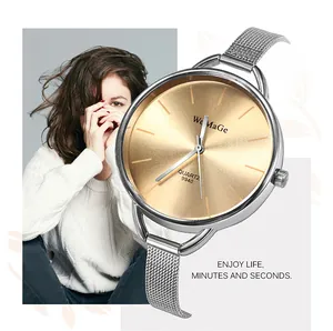 Dettaglio dell'orologio da donna con grande quadrante dorato e cinturino a rete