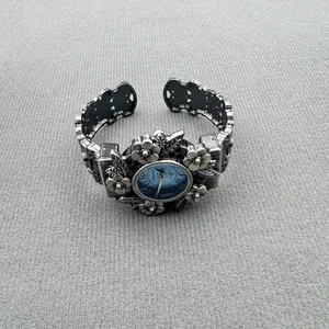 Nahaufnahme einer silbernen Vintage-Armreif-Uhr mit detaillierten Blumen-Gravuren