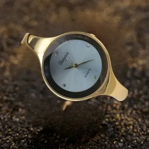 Primo piano di un elegante orologio da polso a quarzo da donna dorato con indici in strass
