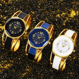 Vista dettagliata di tre eleganti orologi a bracciale dorati in nero, blu e bianco.