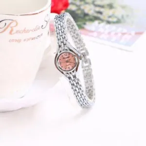 Primo piano di un orologio da polso al quarzo argento da donna con delicato quadrante rosa