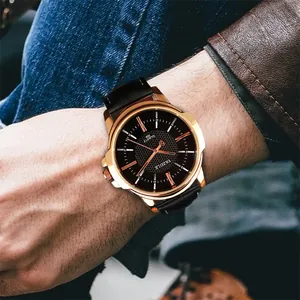 Detalle del reloj de cuarzo Yazole para hombre con correa de cuero negro y caja dorada