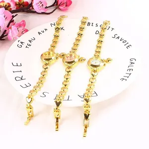 Tre eleganti orologi da donna con cinturino a cuore in oro su un piatto decorativo.