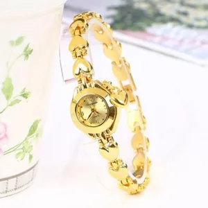 Vista dettagliata di un orologio a bracciale dorato a forma di cuore da donna su supporto chiaro