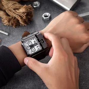 Dettaglio dell'orologio oversize Oulm in stile militare indossato sul polso con oggetti.
