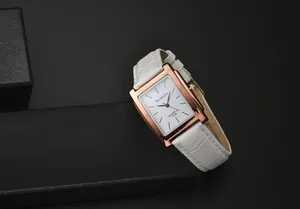 Dettaglio dell'elegante orologio quadrato con cassa in oro rosa e cinturino in pelle bianca