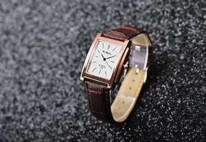 Dettaglio di un elegante orologio al quarzo rettangolare da uomo con cinturino marrone