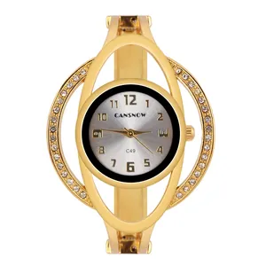 Dettaglio dell'orologio rigido da donna dorato con lunetta in strass e quadrante sunray