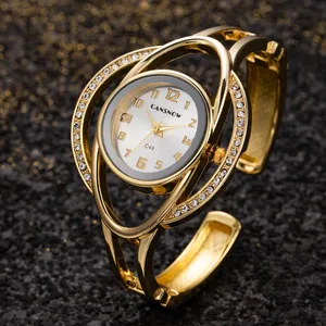 Dettaglio dell'orologio a bracciale dorato con strass e movimento al quarzo
