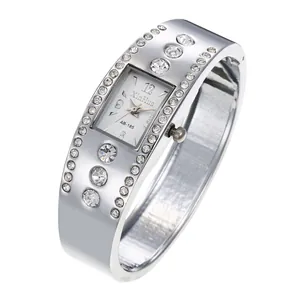 Primer plano del reloj de brazalete plateado con esfera cuadrada y pedrería brillante