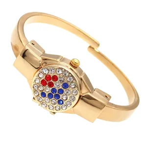 Detail of gold lady bangle watch with colorful rhinestone encrusted flip cover