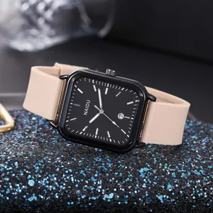 Primo piano di un moderno orologio al quarzo rettangolare con quadrante nero e cinturino.