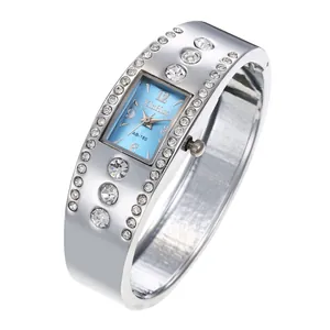 Detalle de elegante reloj de brazalete plateado con esfera azul y pedrería
