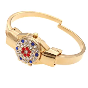 Detail of golden flip-top bangle watch with colorful rhinestone patterns for women
