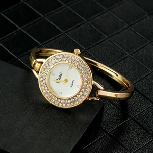 Detalle de un reloj de pulsera dorado para mujer con un bisel de cristales brillantes