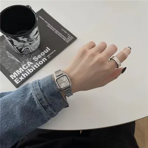 Élégante montre femme carrée minimaliste avec bracelet en acier argenté au poignet.