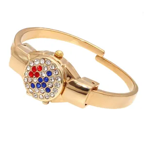Detailed view of women's gold bangle watch with flip cover and rhinestone flower design