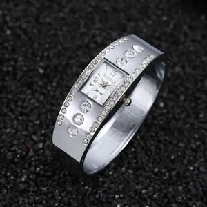 Detalle del reloj de pulsera plateado con esfera cuadrada y diamantes