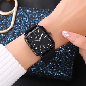 Elegante orologio al quarzo rettangolare con cinturino in silicone nero visto sul polso