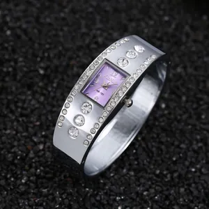 Vista detallada de un elegante reloj brazalete de plata con esfera púrpura y cristales
