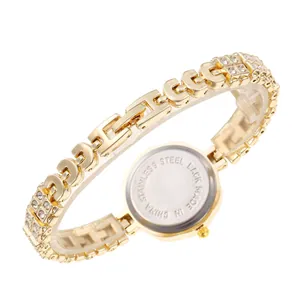 Dettaglio dell'orologio dorato di lusso con cinturino in strass e fondo in acciaio.
