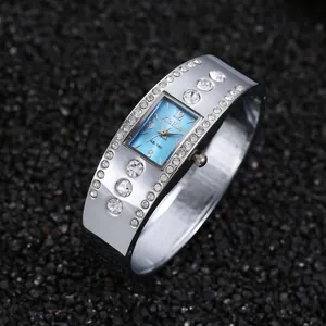 Primer plano de un elegante reloj de brazalete con esfera azul cuadrada y diamantes.