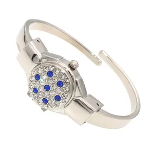 Detailed close-up of a stylish ladies bangle watch featuring a blue and white rhinestone flip cover