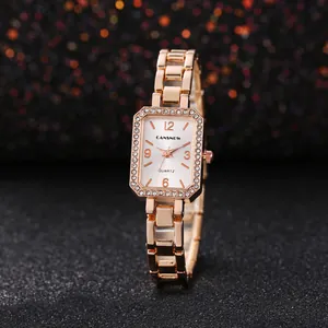 Close-up van een elegant roségouden vierkant horloge met kristallen lunette en witte wijzerplaat.