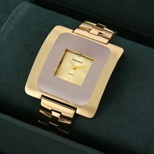 Primo piano di un orologio al quarzo vintage dorato con ampio quadrante quadrato.