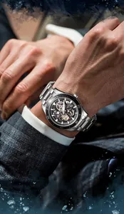 Detail of Mark Fairwhale men's skeleton mechanical watch on wrist with water splash