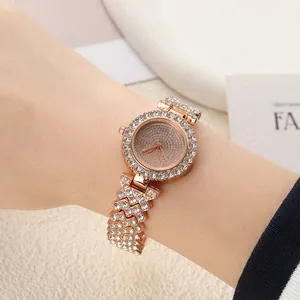 Détail d'une montre pour femme en or rose avec cadran et bracelet sertis de strass