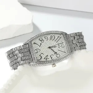 Close-up of luxury tonneau-shaped watch with full diamond setting and large numerals.