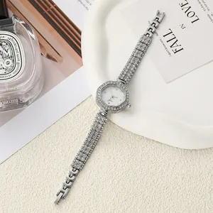Close-up of elegant silver flower-shaped rhinestone ladies quartz watch on white tray