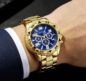 Close-up of a luxury gold-tone men's business watch with a deep blue dial on a wrist.