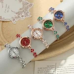 Detail view of stylish women's clover bracelet watches with colorful dials and crystal accents
