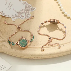 Close-up detail of rose gold clover bracelet watch with adjustable chain and rhinestones