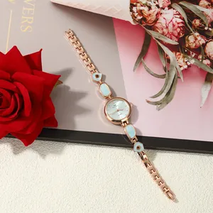 Close-up detail of women's rose gold quartz watch with blue enamel irregular bracelet