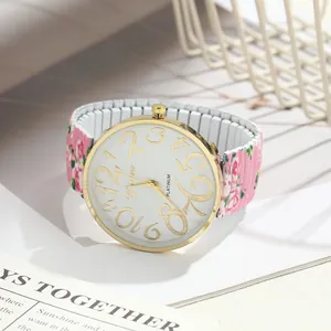 Detailed view of women's quartz watch with floral stretch band and large gold numerals