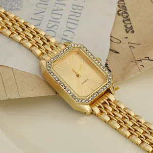 Close-up detail of an elegant gold rectangular women's watch with crystal-encrusted bezel